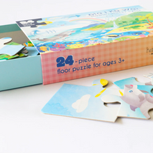 Load image into Gallery viewer, Side view of open  puzzle box reading "24 - piece floor puzzle for ages 3+," showing three puzzle pieces close-up