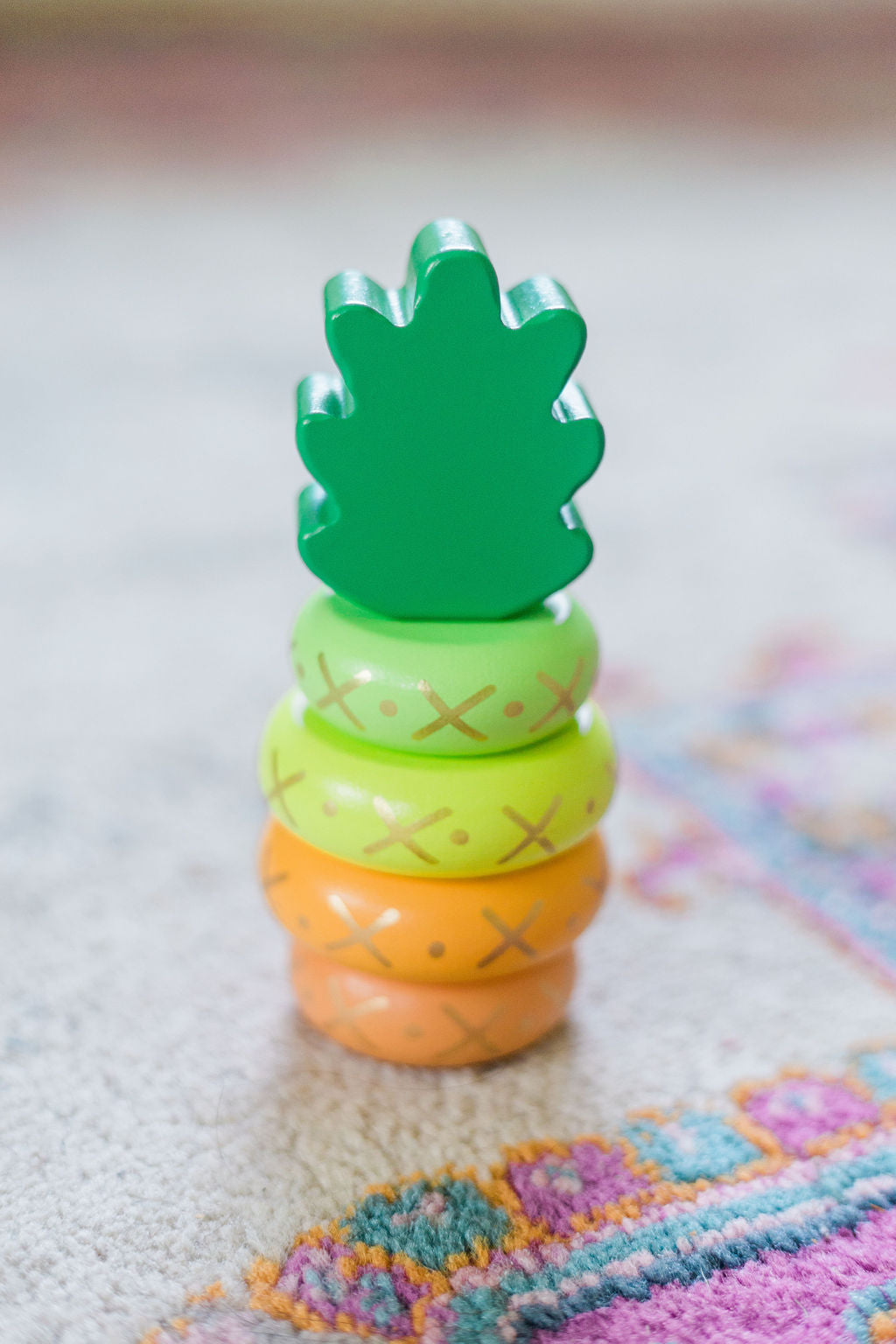Yellow wooden pineapple stacking toy.