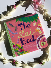 Load image into Gallery viewer, Cover of a pink book with green palaka print spine and illustrations of different flora leis reading "The Lei Book"