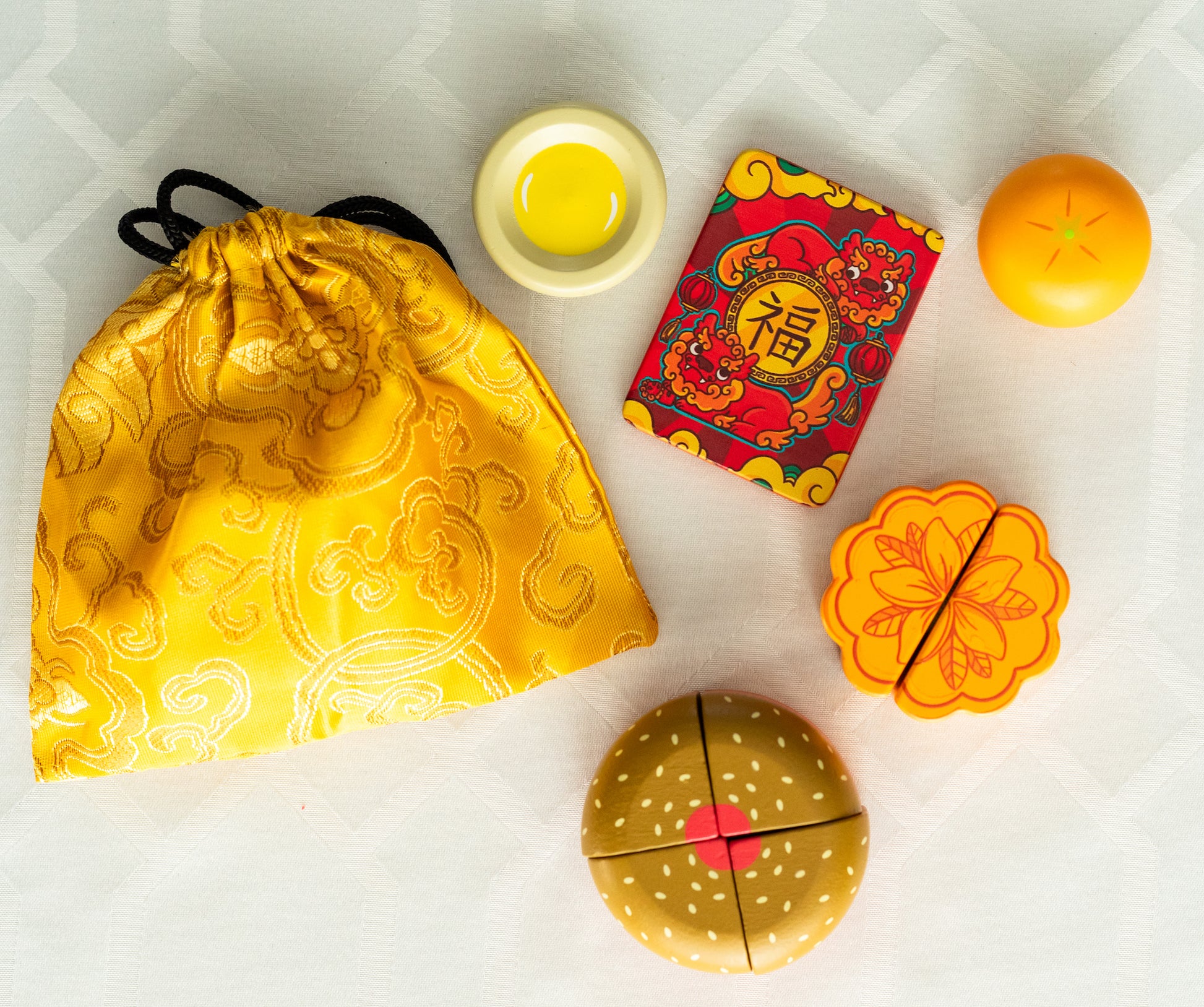 Golden Pouch, red lucky envelope, and play food (egg tart, tangerine, mooncake with plumeria design, and 4-piece gau)