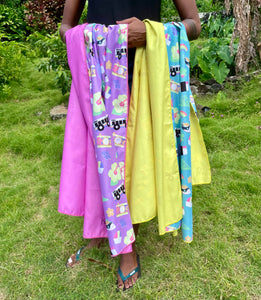 Woman holding brightly colored towels draped from her arms