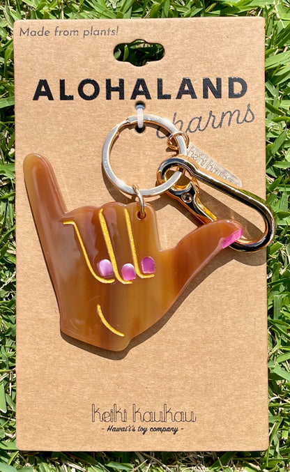 Shaka keychain on a brown card with grass background