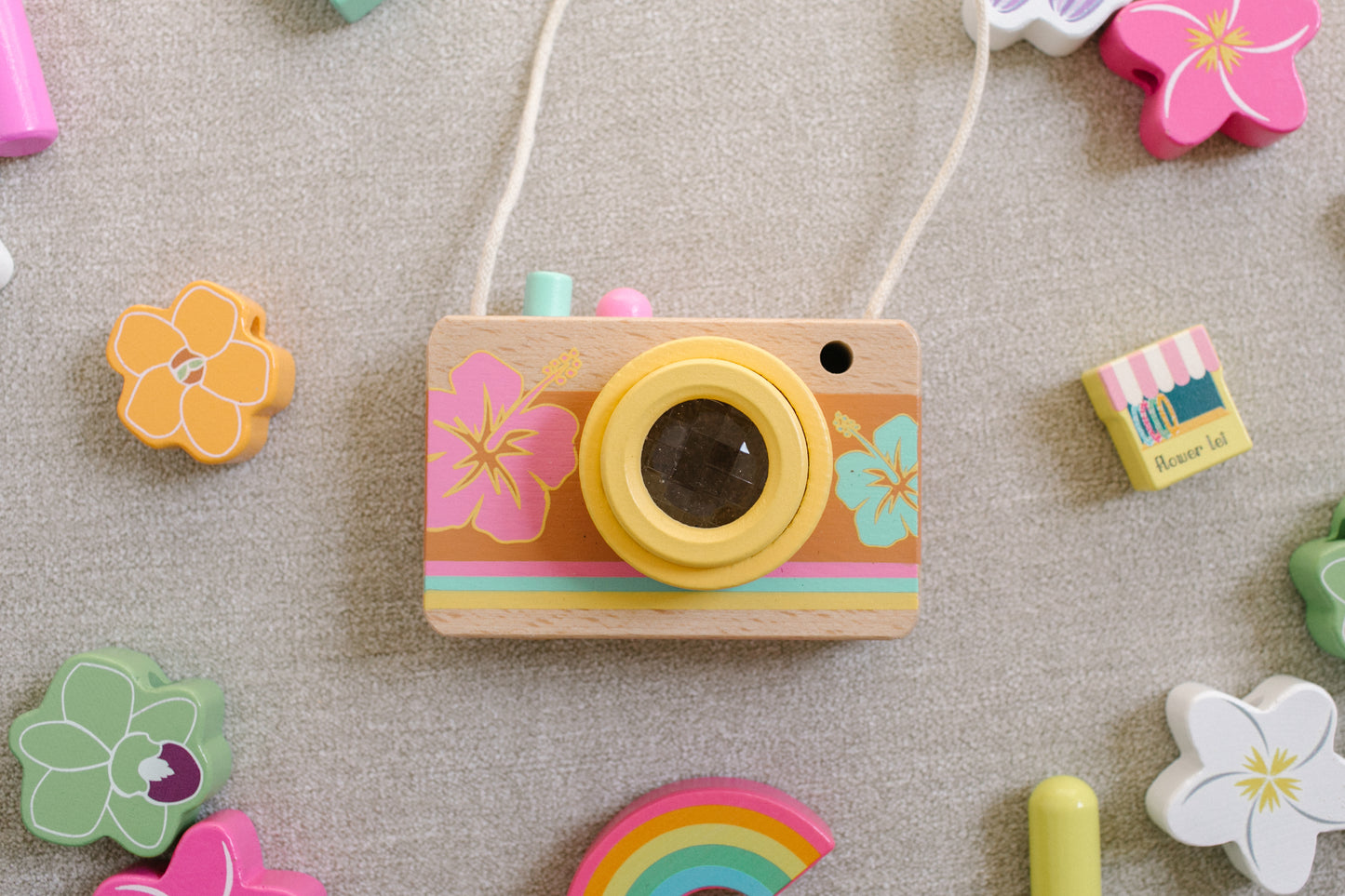 Wooden camera surrounded by wooden flower beads