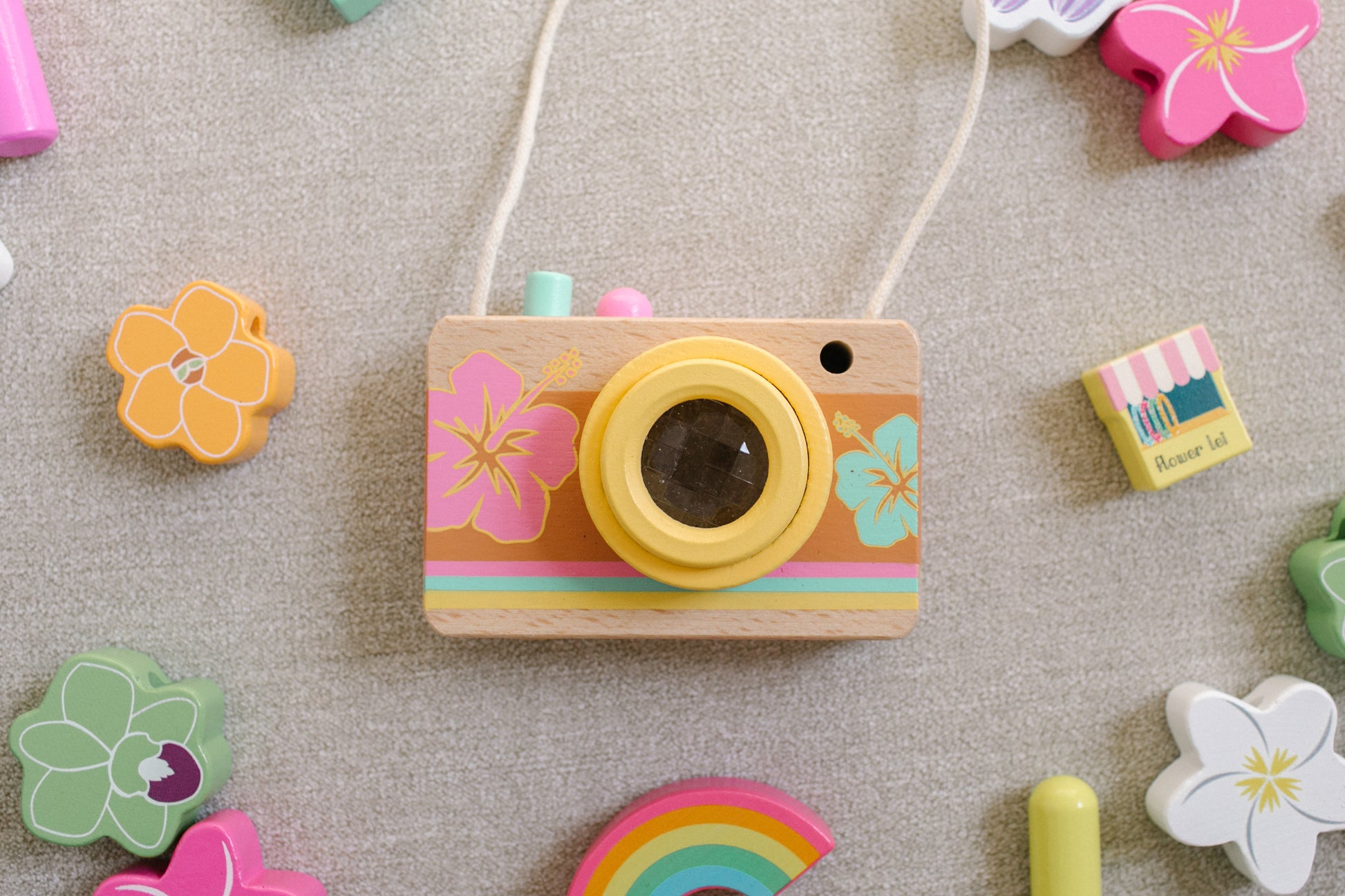 Wooden camera surrounded by wooden flower beads