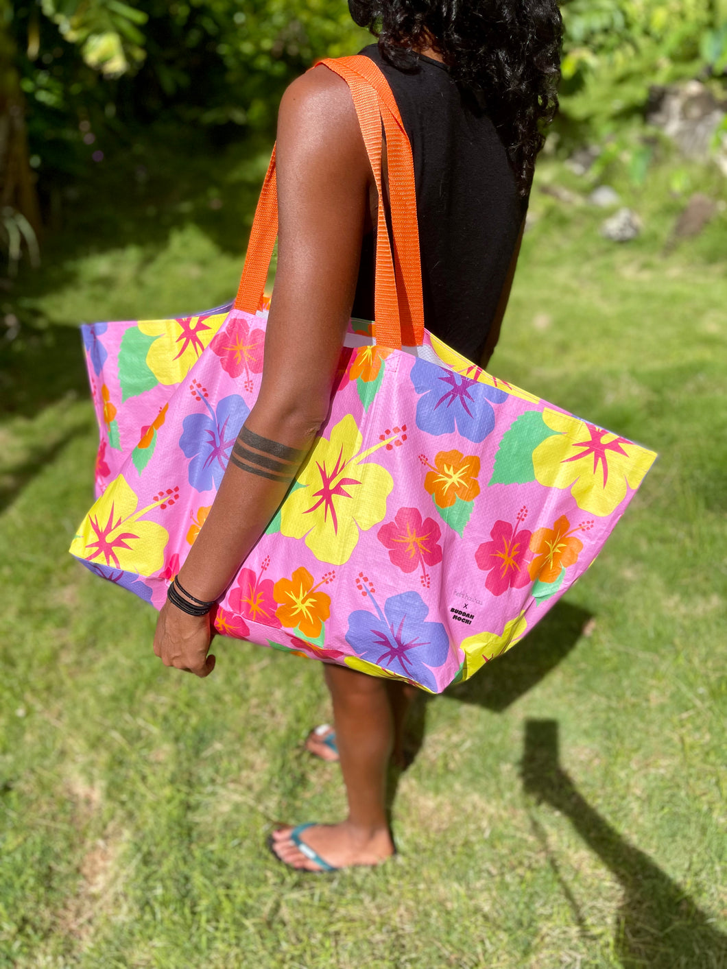 Woman carrying a pink tote bag with a flower print