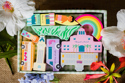 ALOHALAND blocks in green palaka box packaging, surrounded by flowers