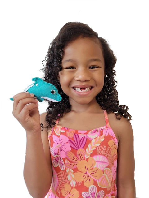 Little girl holding sewn teal dolphin