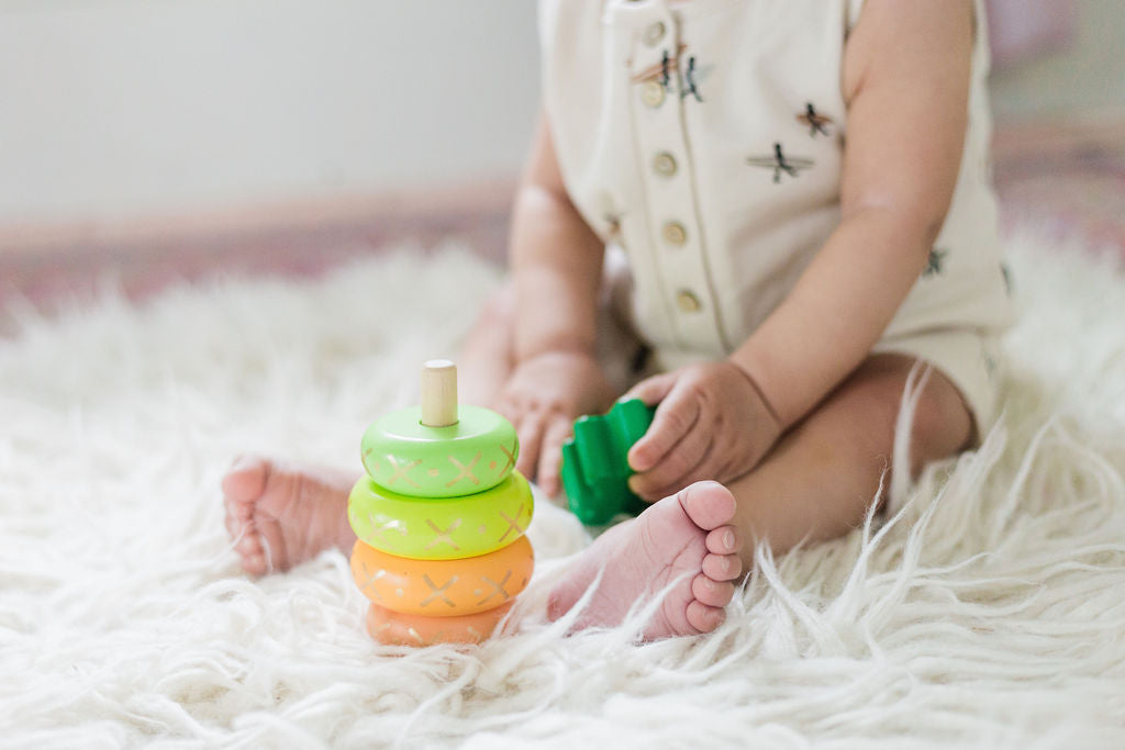 baby with the yellow wooden pineapple stacking toy