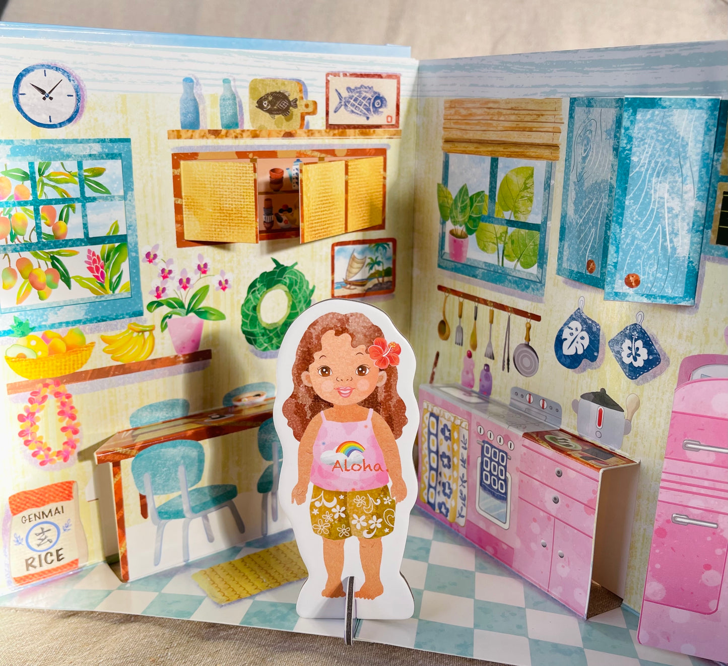 Cardboard doll of a little girl standing in the kitchen page of the Pop-up doll house book