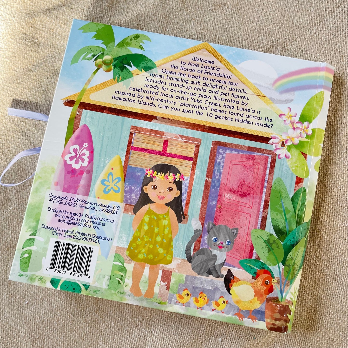 Back cover of Pop-Up Dollhouse with illustration of little girl with black hair next to a cat and chickens in front of a house