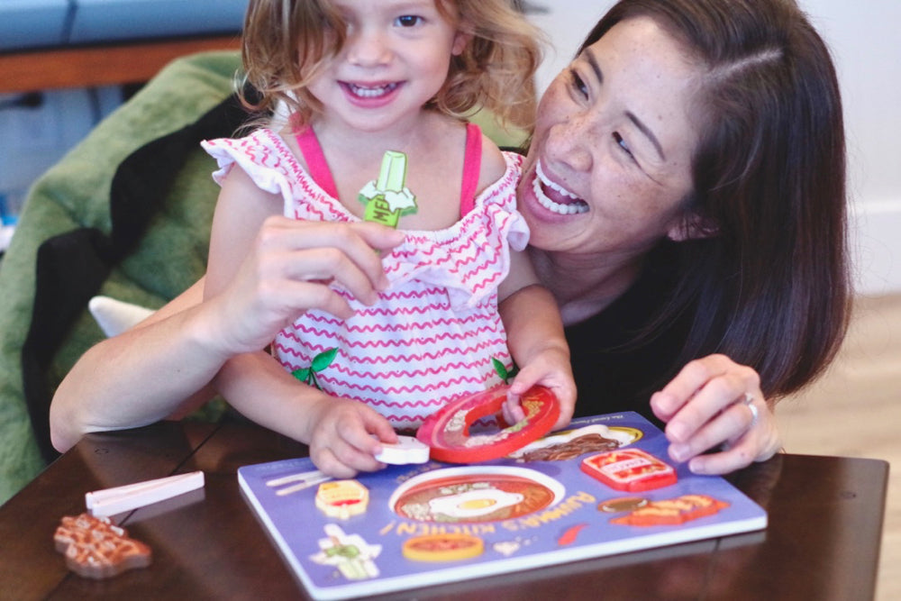 Mother and daughter playing with Korean food shaped puzzle pieces