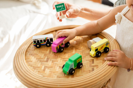 Baby playing with pink trolly shaped wooden car